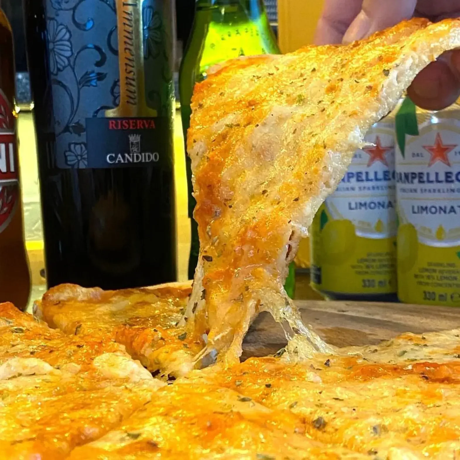 Et stykke pizza løftes med smeltet ost